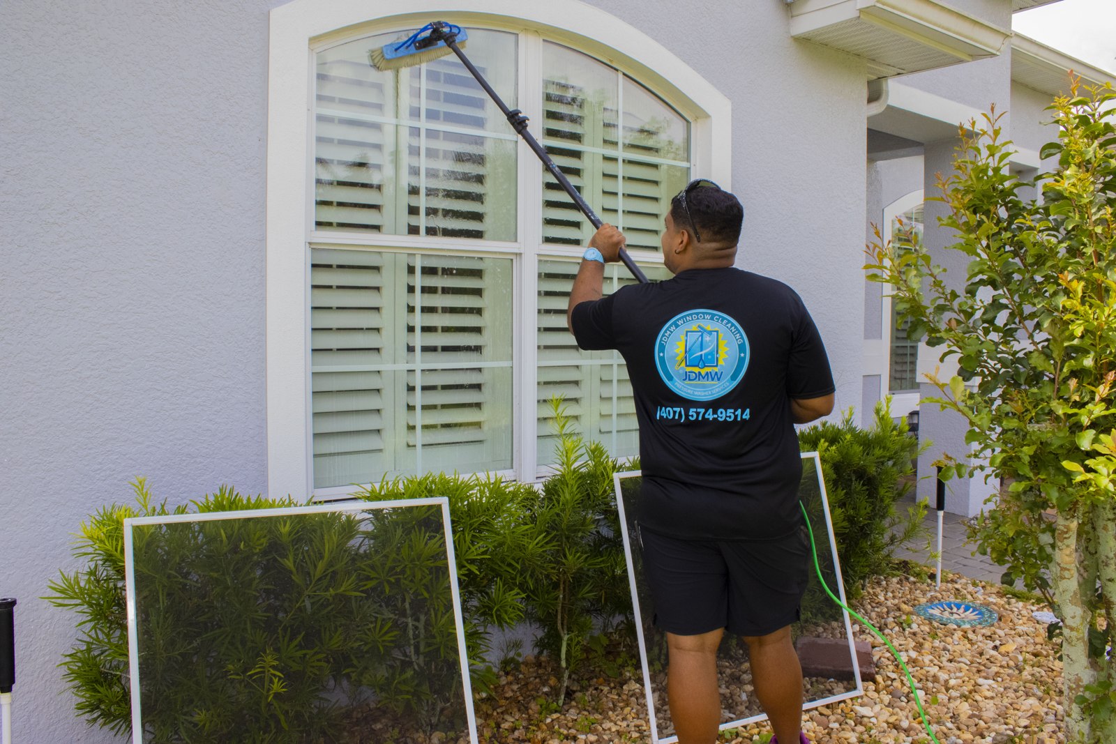 French Window Cleaning in Saint Cloud, FL: technician washing a window with divided glass panes